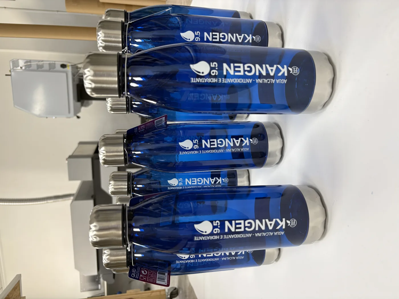 Botellas corporativas azules con impresión de marca en el taller de VL Rotulaciones