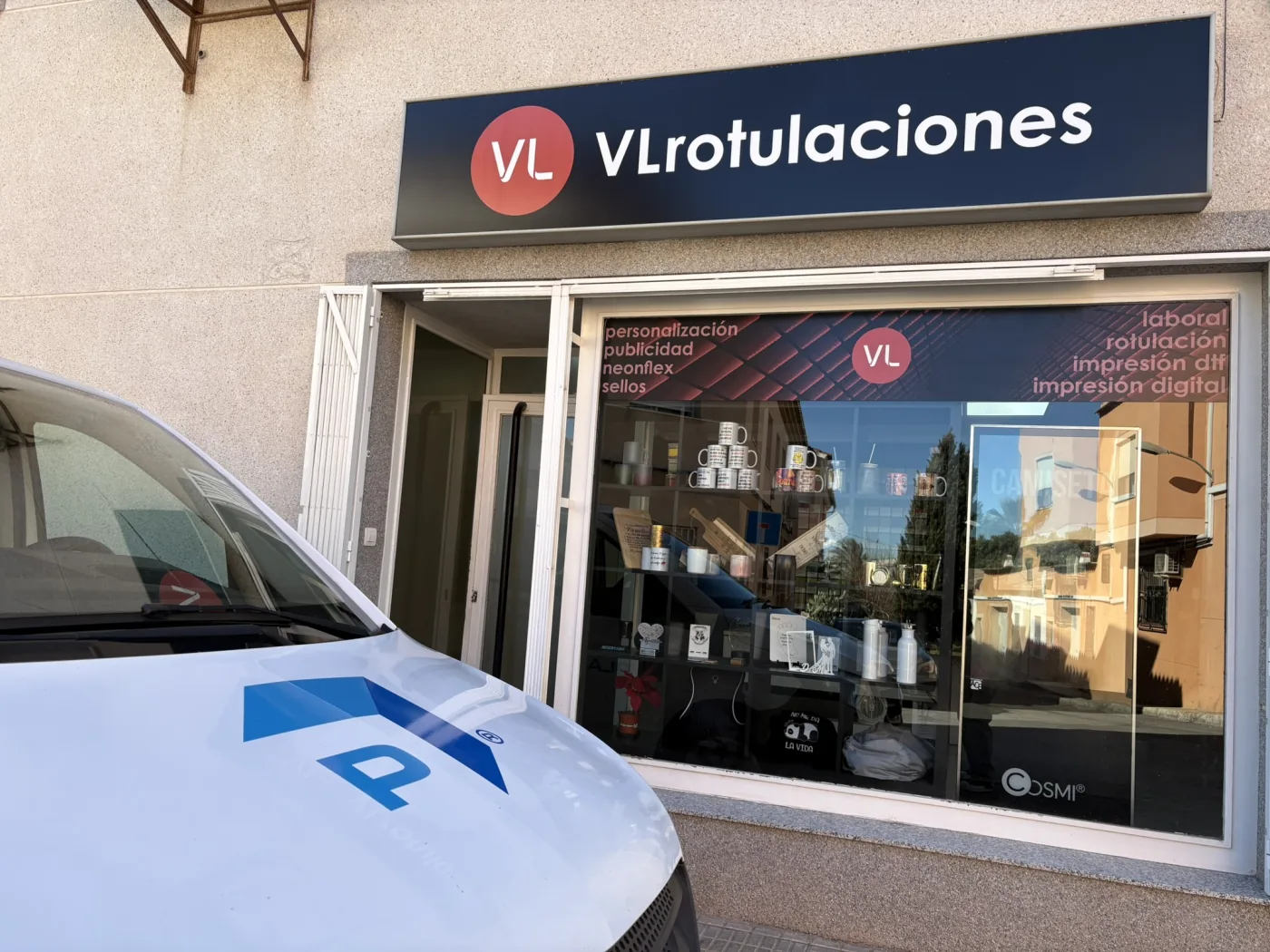 Entrada y escaparate de VL Rotulaciones con muestras de productos personalizados